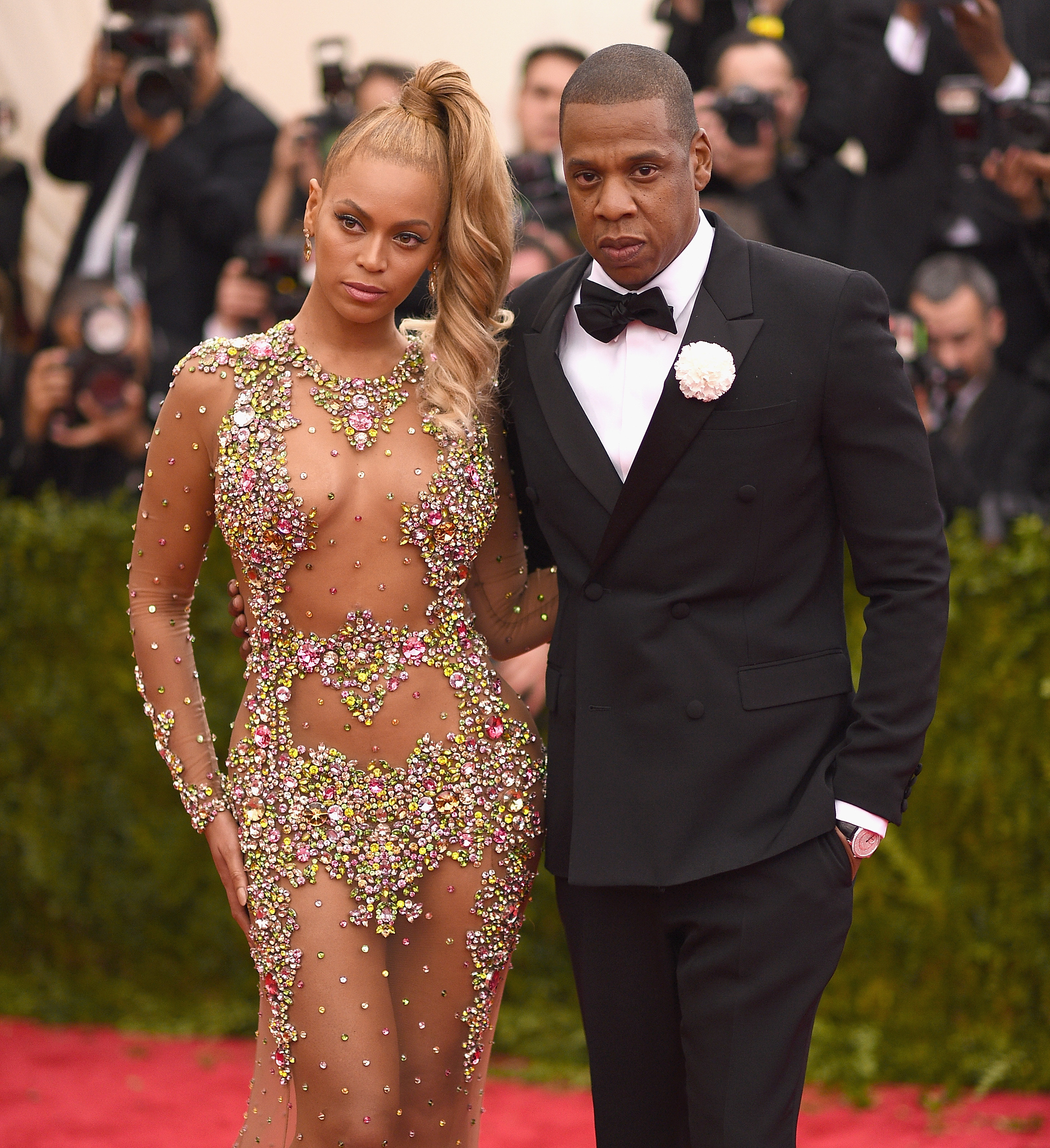Beyonce and Jay-Z at Met Gala in 2015 where Beyonce is wearing a bedazzled dress and Jay-Z a suit