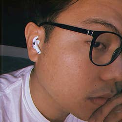 reviewer using their AirPods with the hook covers