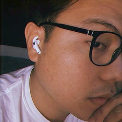 reviewer using their AirPods with the hook covers