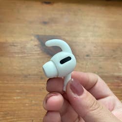 reviewer hand hold their AirPod with the silicone hook
