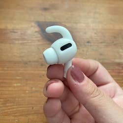 reviewer hand hold their AirPod with the silicone hook