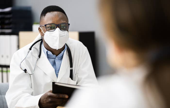 Doctor speaks to patient with mask