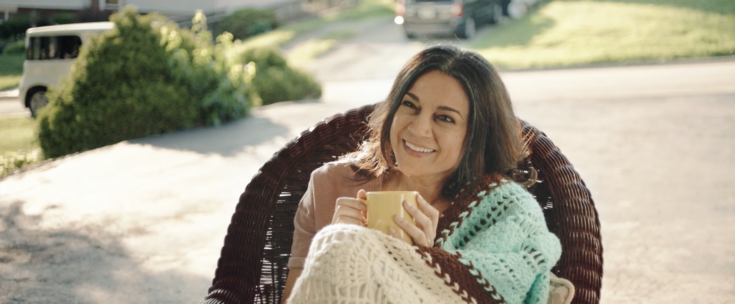 Monica&#x27;s mom smiling with a cup of tea in her hands