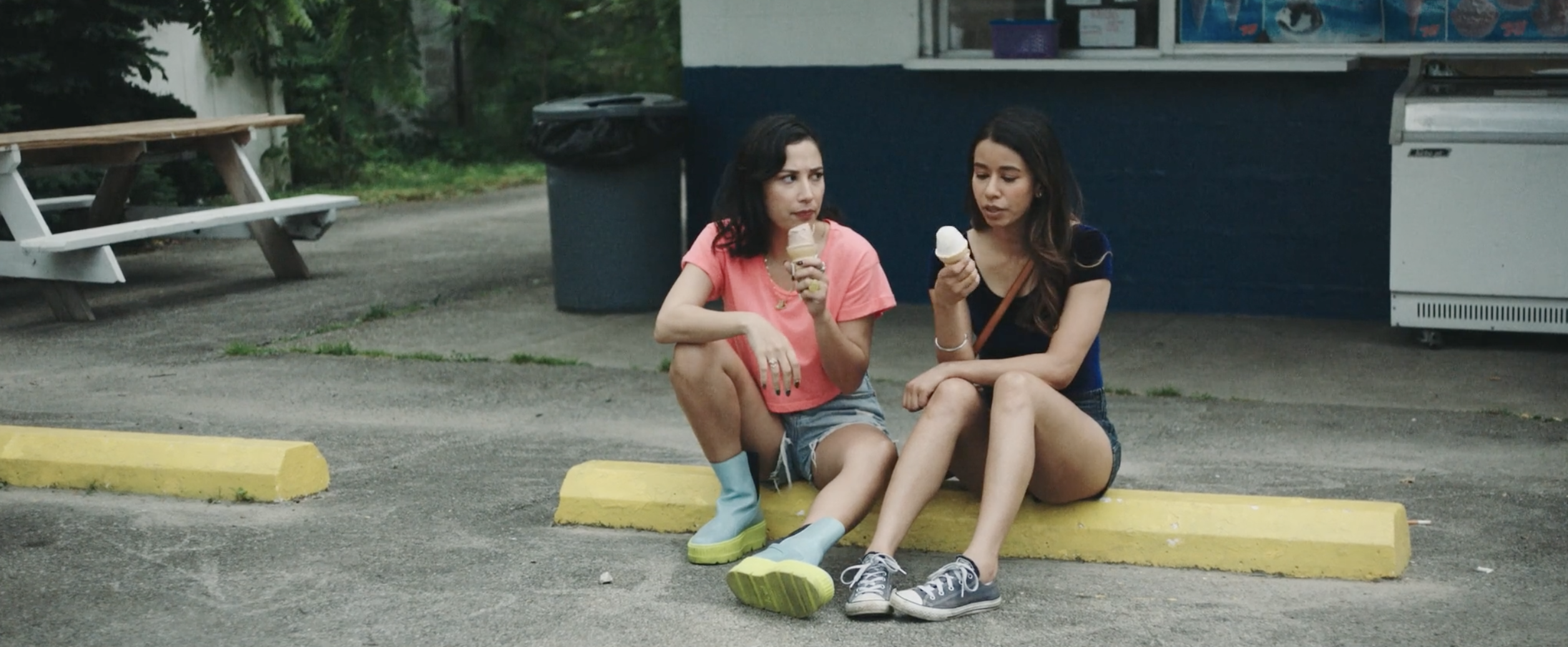 Monica and Krista eating ice cream in a parking lot