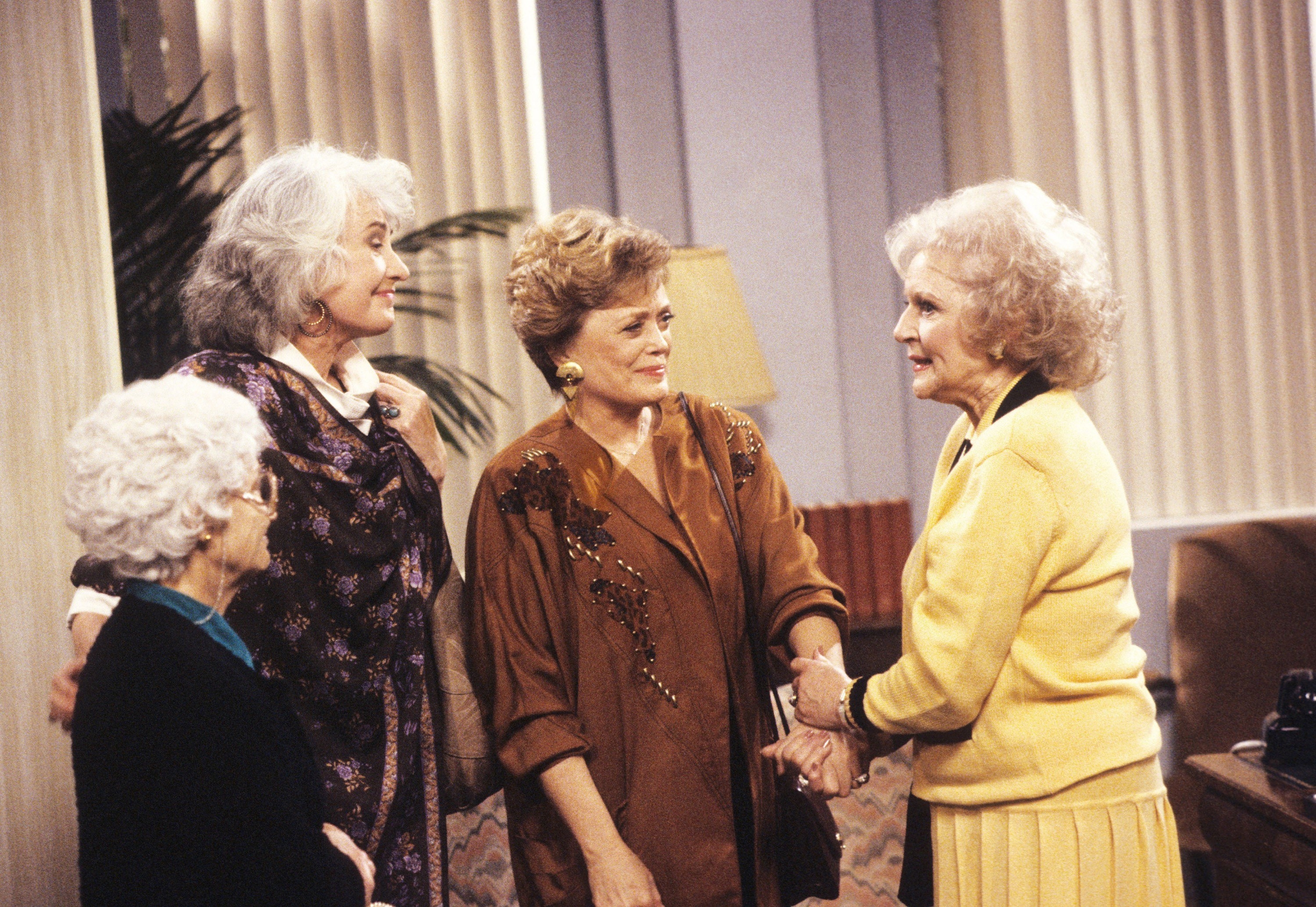 The four golden girls smiling at each other