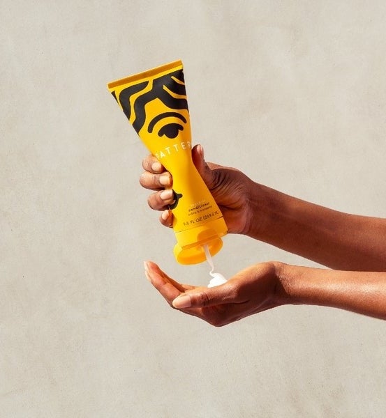 a model squirting out the leave-in conditioner from the bottle