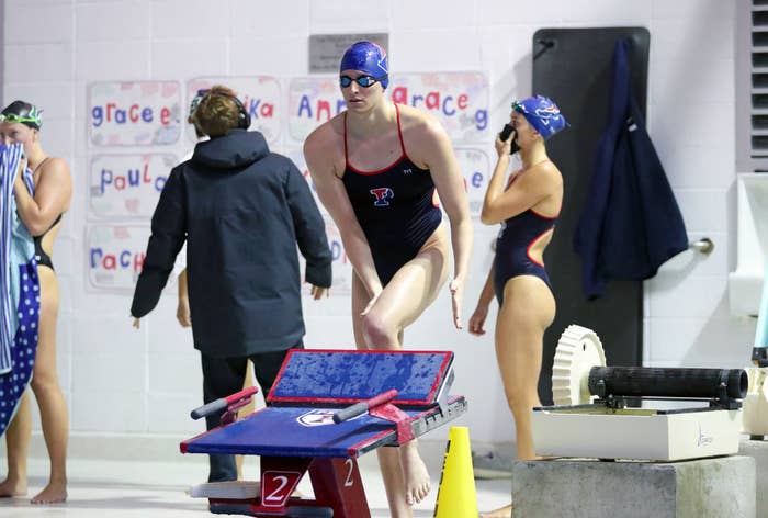 Lia by the pool preparing for a race with other swimmers behind her