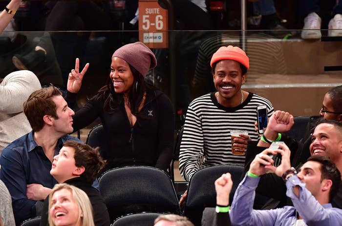 Regina giving the peace sign as she sits next to Ian at a sporting event