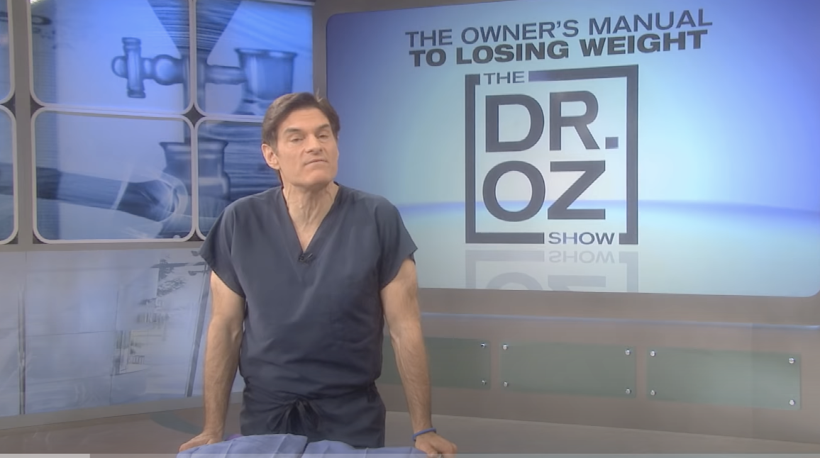 Dr Oz on his show with &quot;The Owner&#x27;s Manual to Losing Weight&quot; text behind him