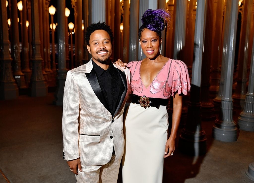 shot of Ian Alexander Jr. in a satin tux alongside his mother, Regina, who&#x27;s sporting purple hair in a top knot and wearing a deep-plunge dress