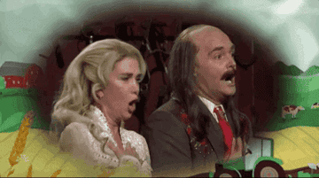 Kristen and Will singing excitedly, with Will wearing a long wig that's bald on top