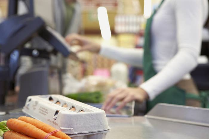 A grocery worker working at the checkout