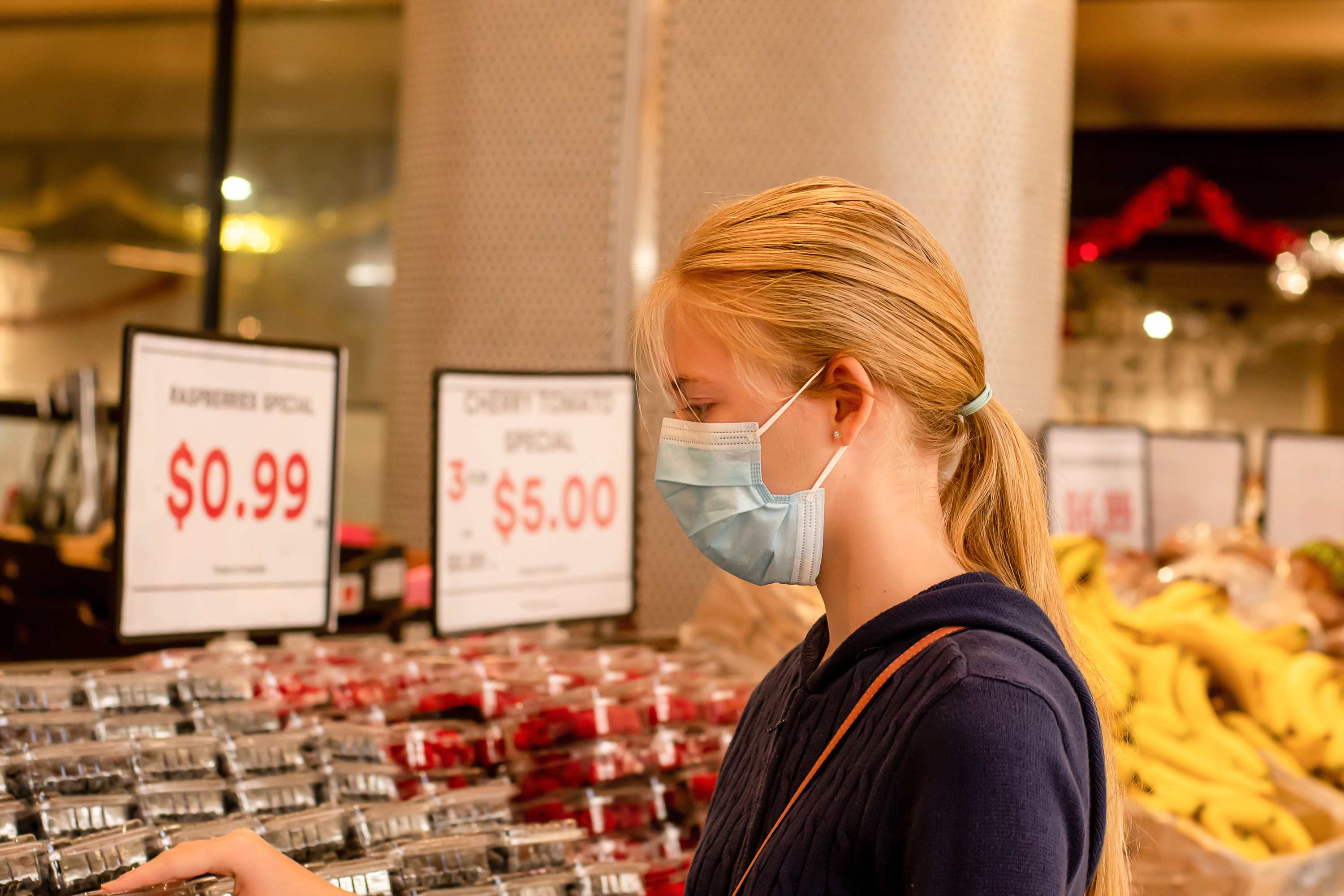 Young adult girl wearing disposable face mask at the grocery store