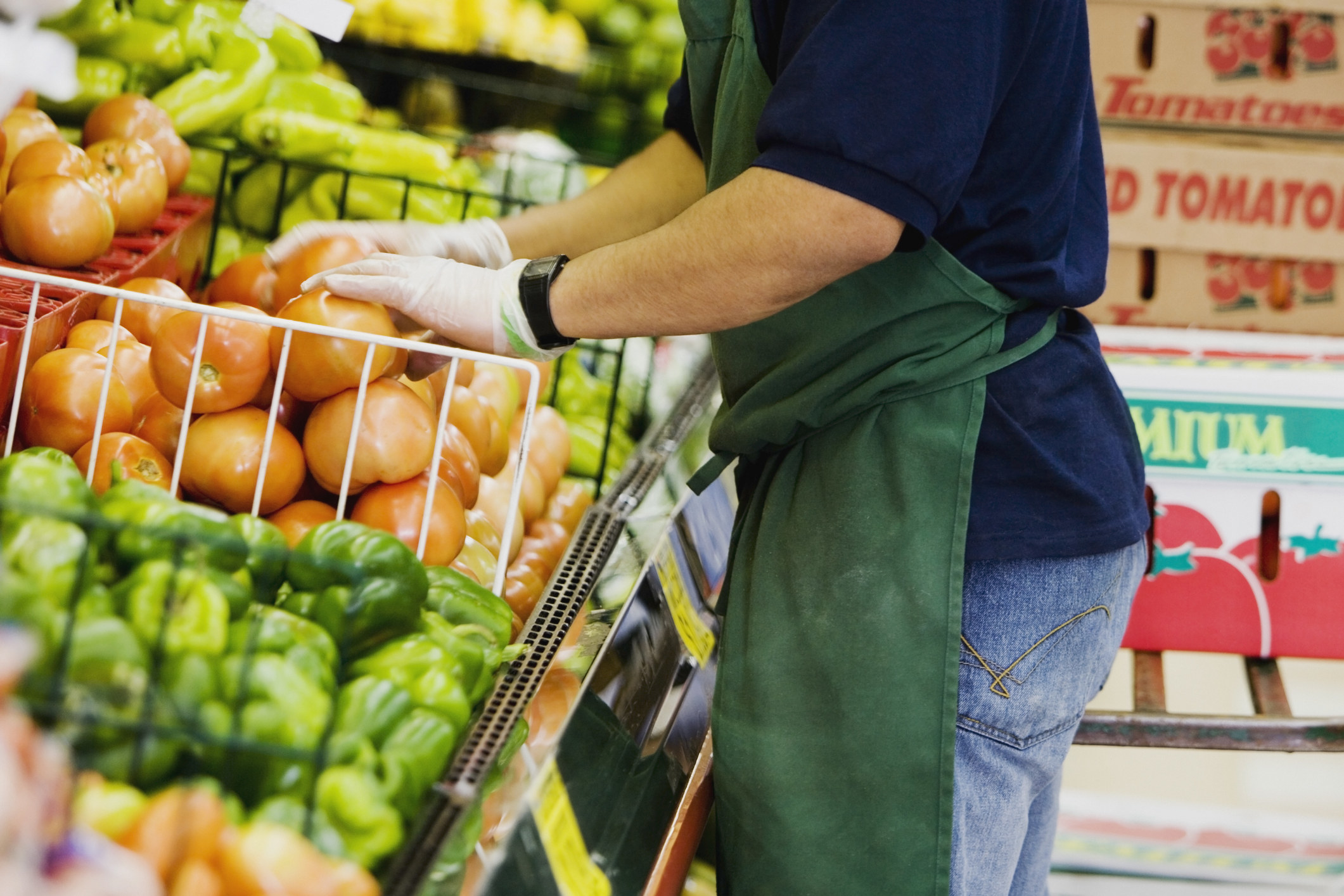 A man stacking shelves at a fruit store