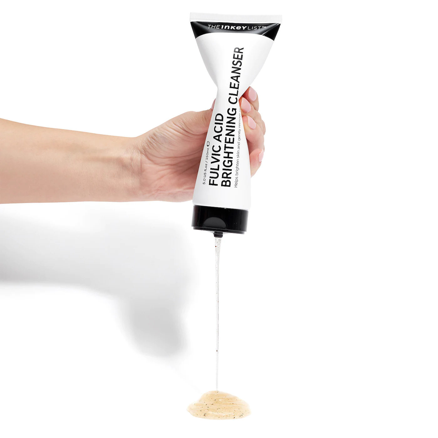Hand squeezing out product from a tube of the fulvic acid cleanser