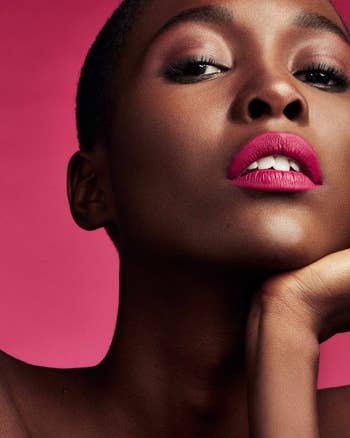 a model wearing a bright pink lipstick
