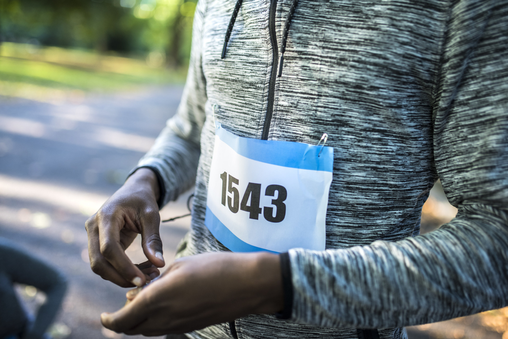 An athlete with their number strapped on their shirt, about to run a marathon