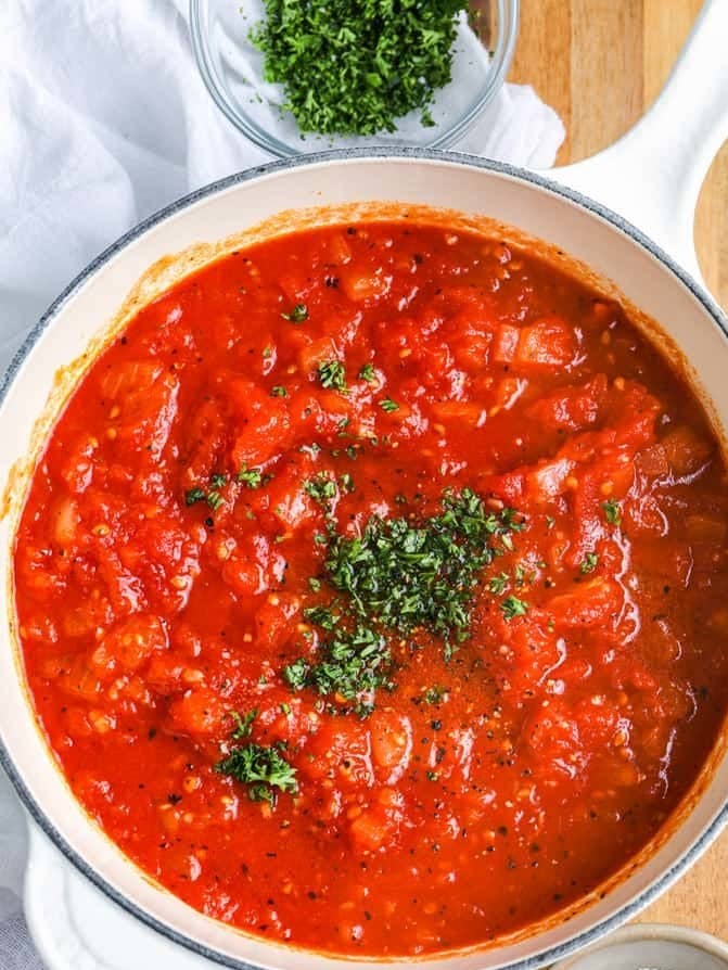 Tomato sauce in a pot with fresh basil.