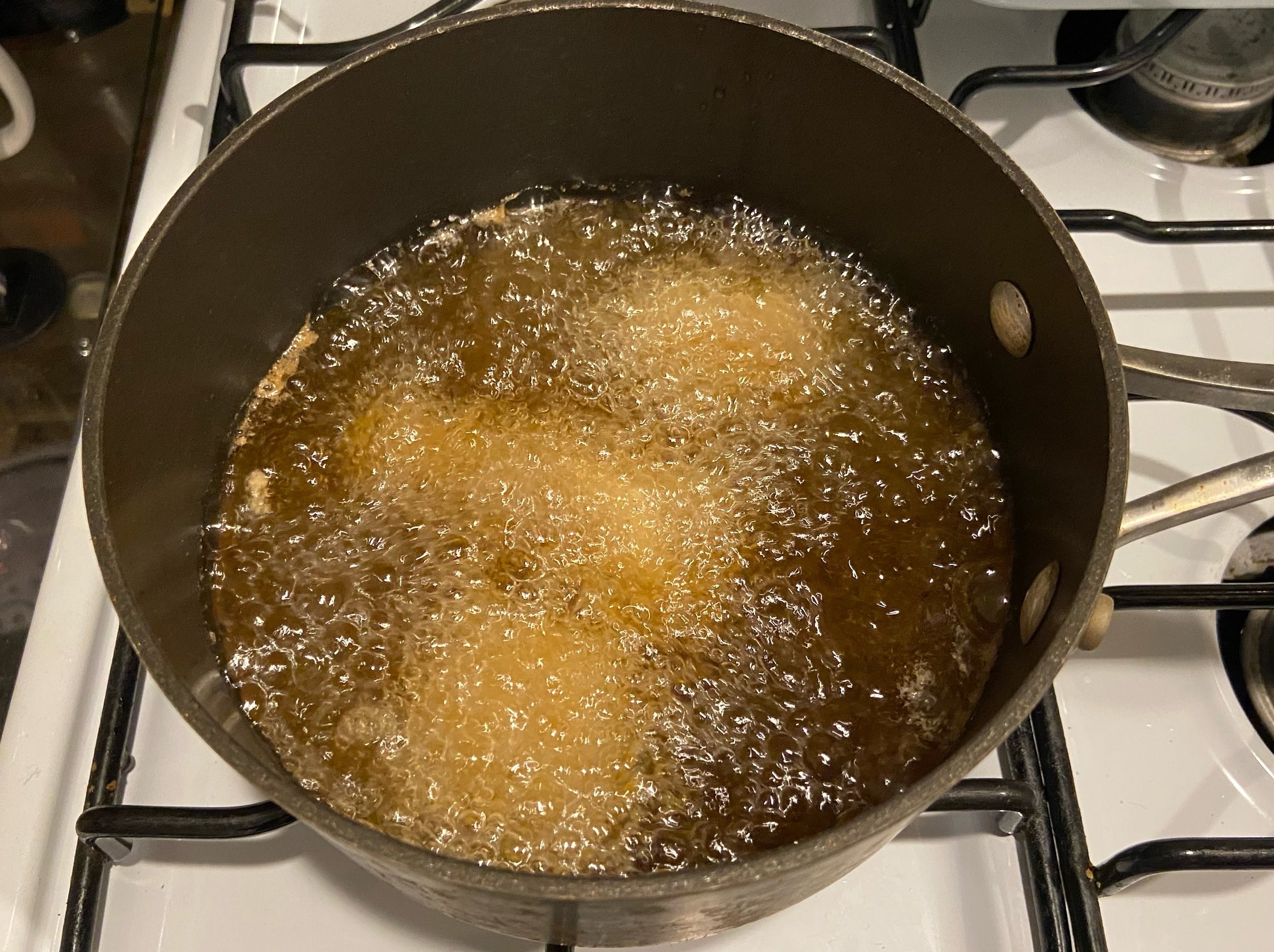 Pieces of chicken frying in the oil.
