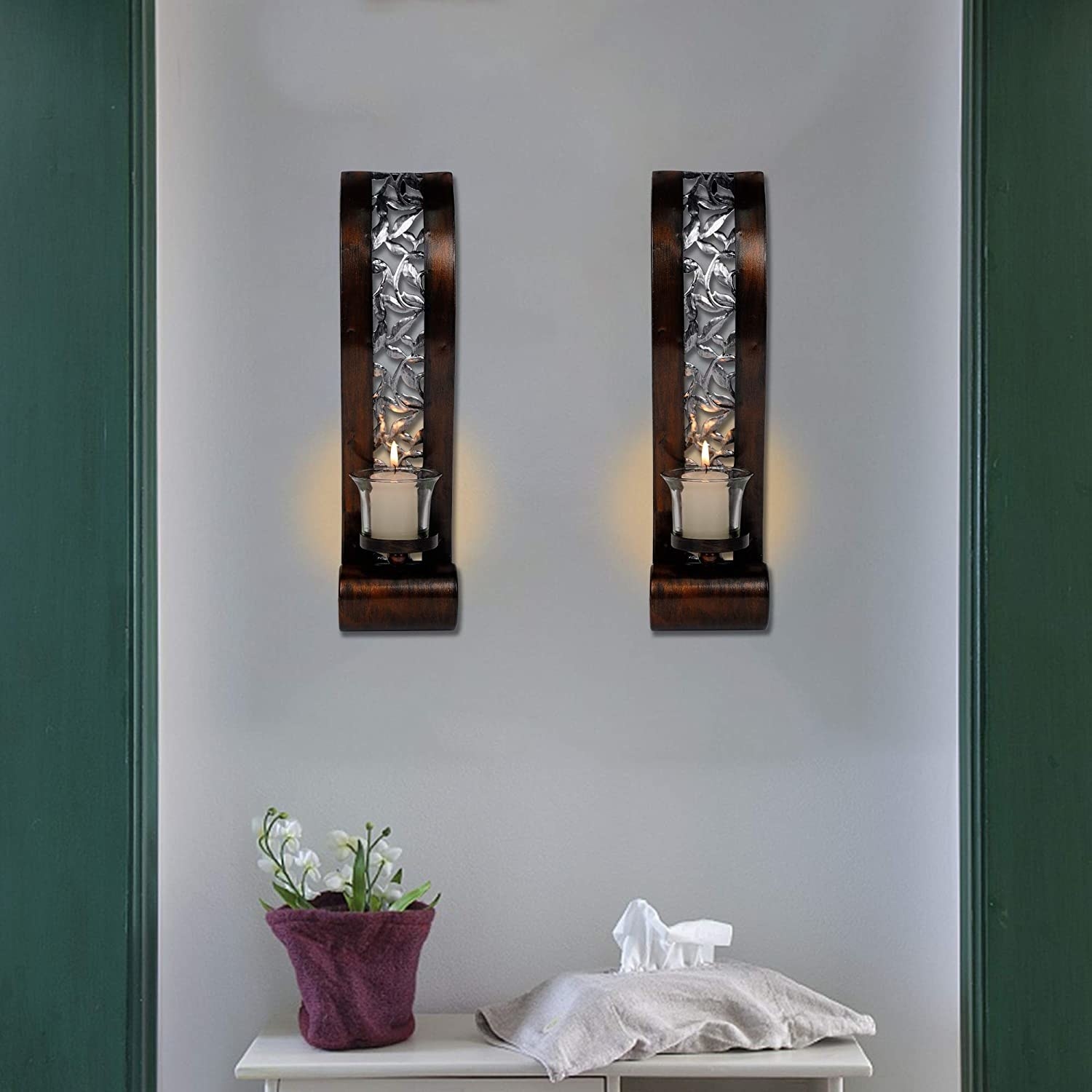 Photo of two of the silver and wood wall sconces with lit candles