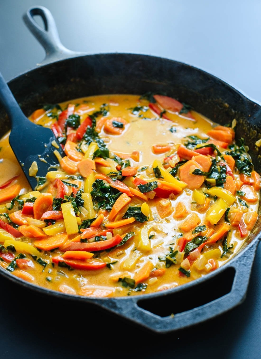A skillet of red curry with vegetables.