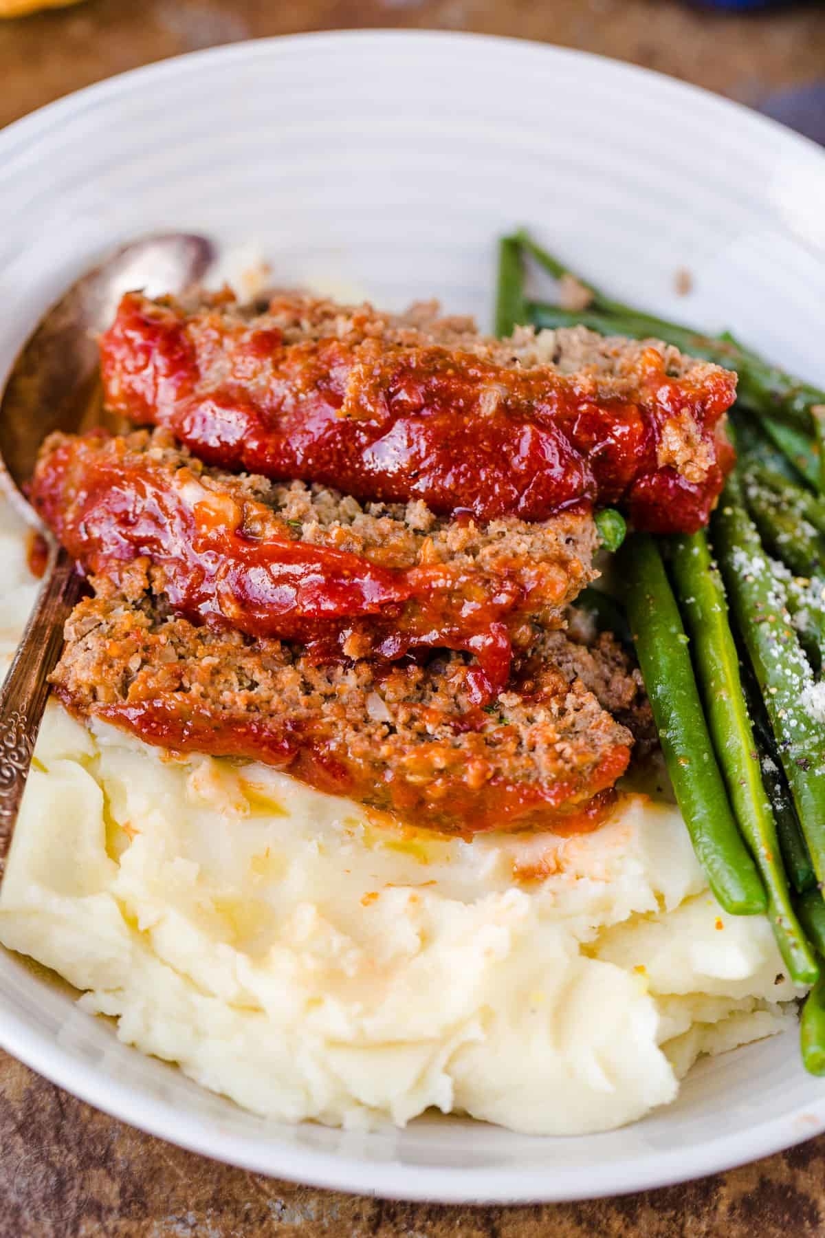 Sliced meatloaf over mashed potatoes.