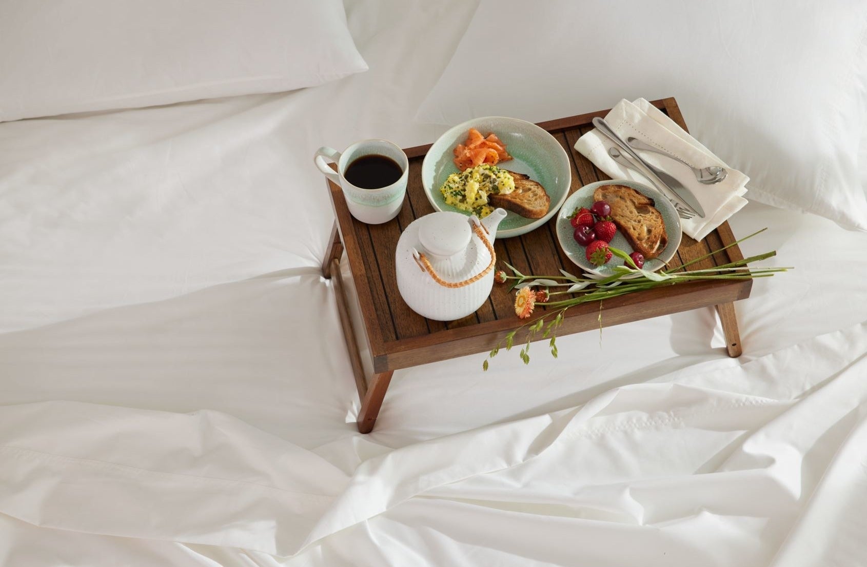 A walnut bed tray with breakfast food atop