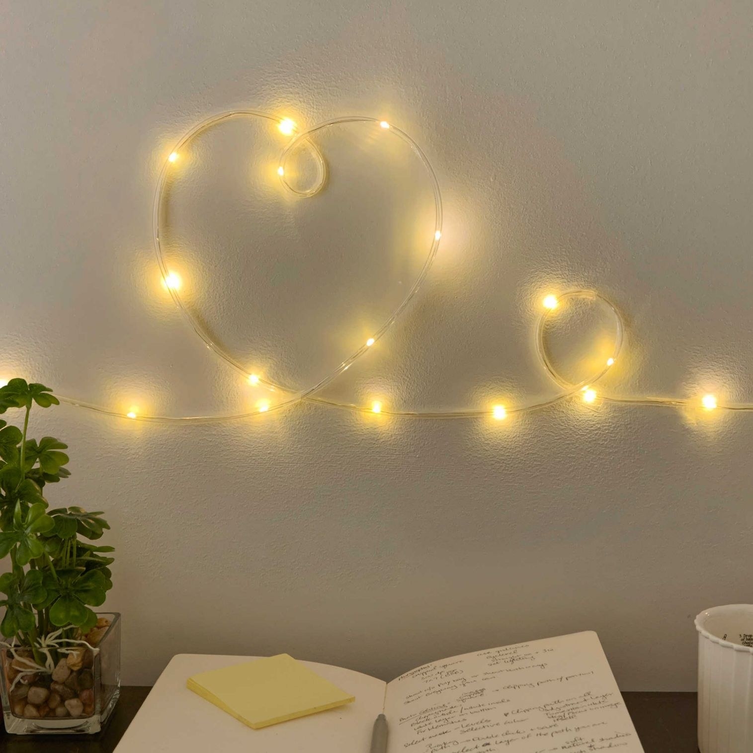String lights on a wall above a desk