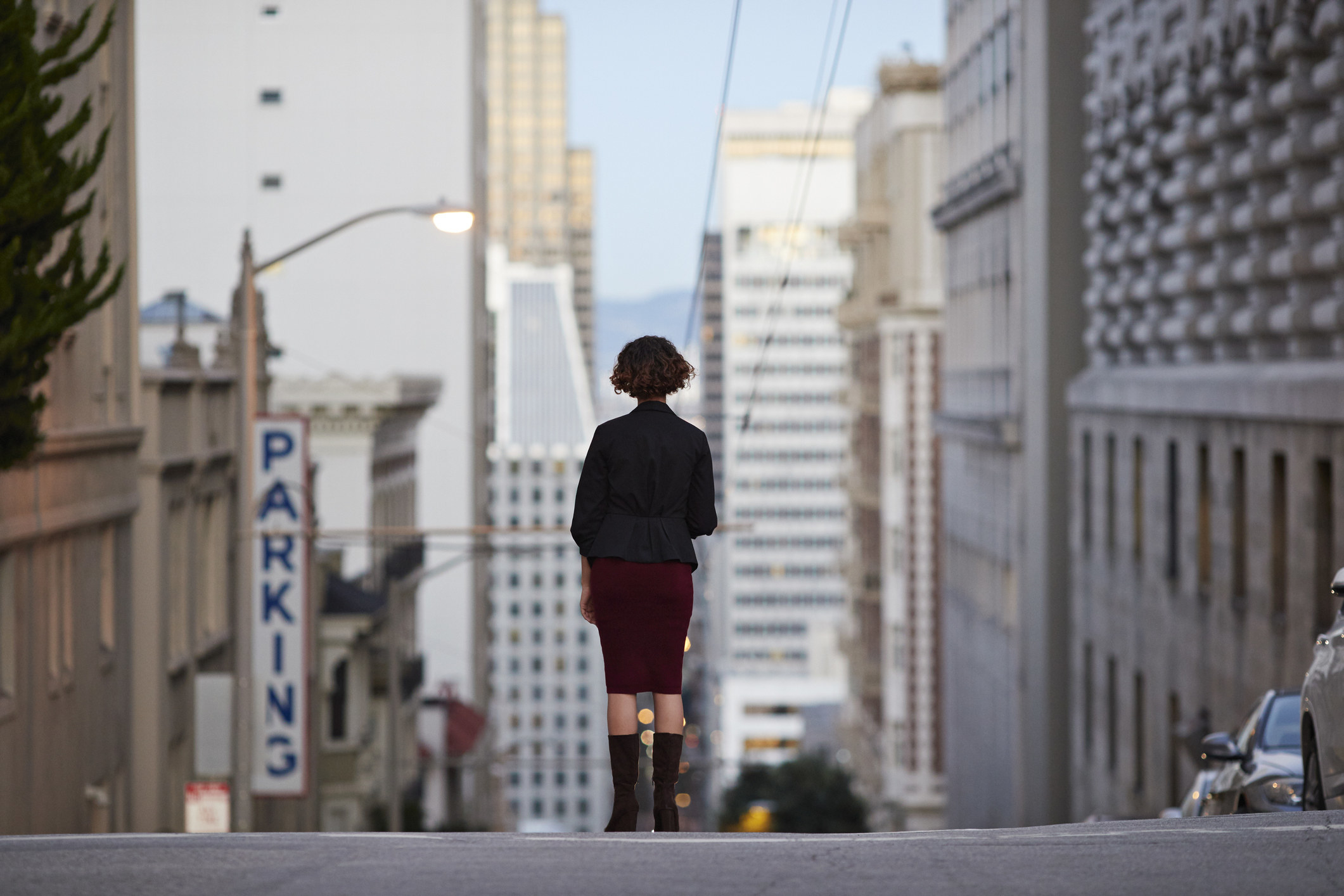 Businesswoman standing on top of steep San Francisco street and looking out