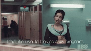 Maddy looking into bathroom mirror