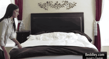 a gif of a model stuffing a duvet inside the beddley cover
