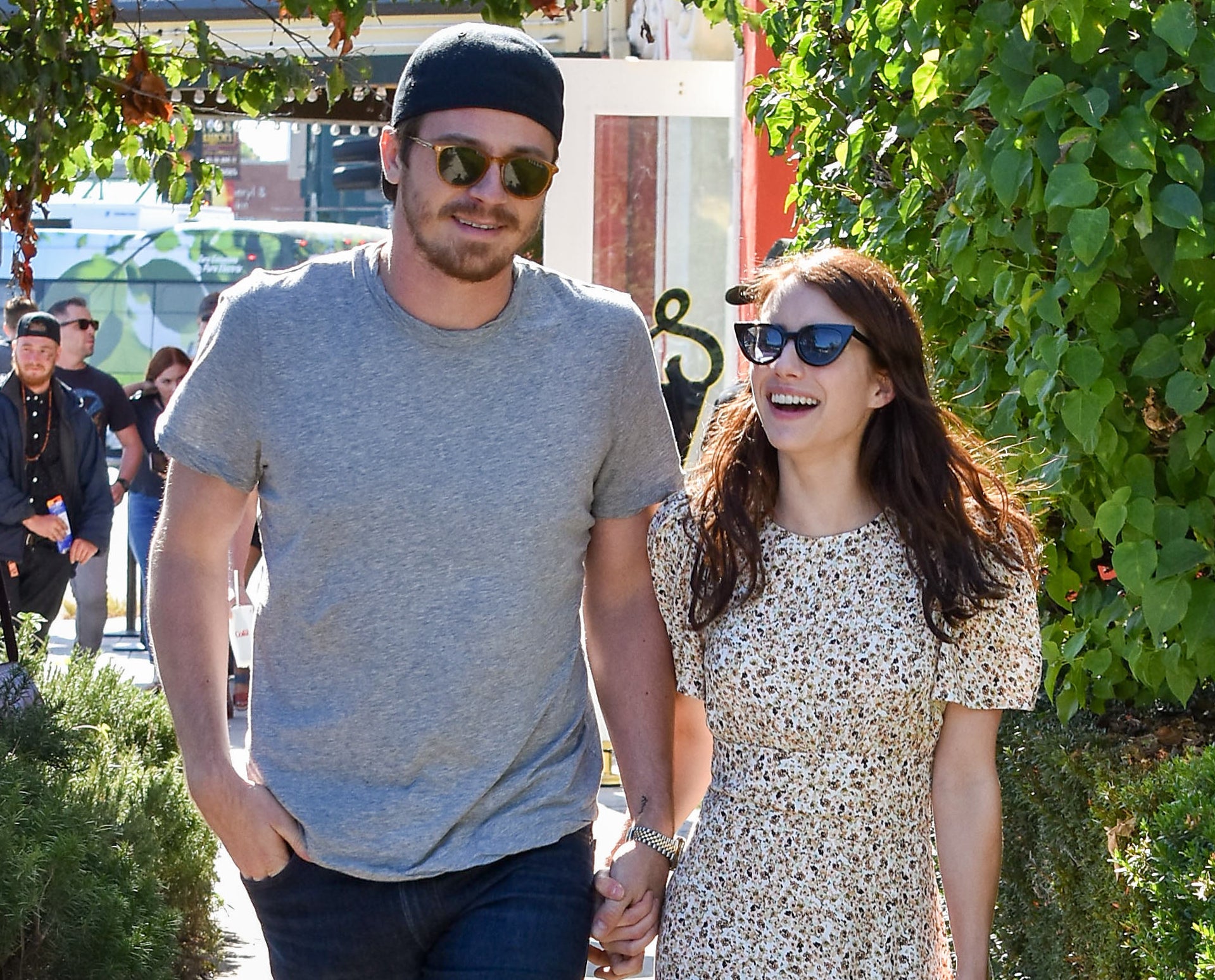 Garrett and Emma hold hands on a walk
