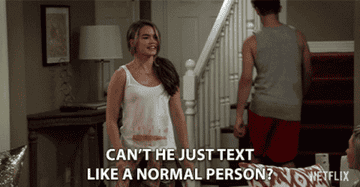 A woman stands in her home and says can&#x27;t he just text like a normal person