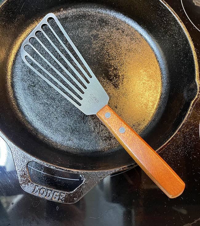 reviewer photo of the fish spatula on top of a cast iron pan