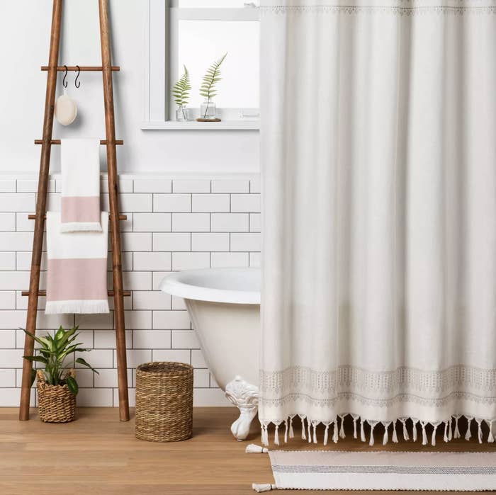 the wooden ladder leaning against a wall with towels hanging on it