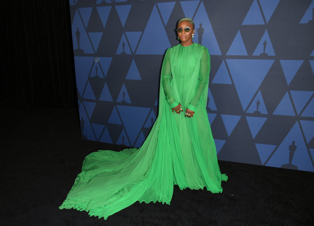 Erivo in green long-sleeved gown and sunglasses