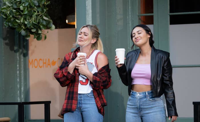 Sophie and her friend Valentina outside of a building savoring cups of coffee in to-go cups
