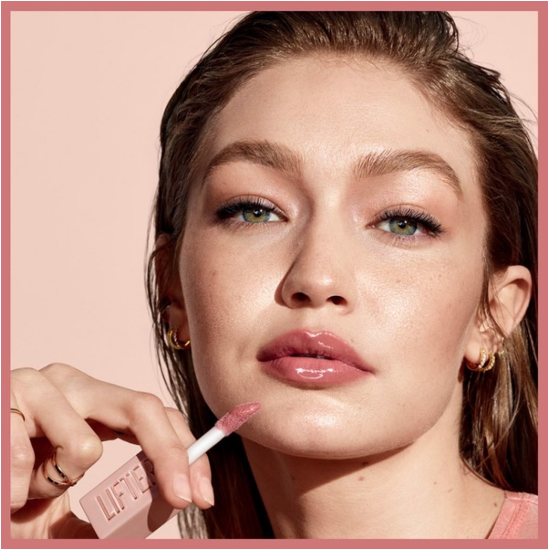 Gigi Hadid applying pink lip gloss