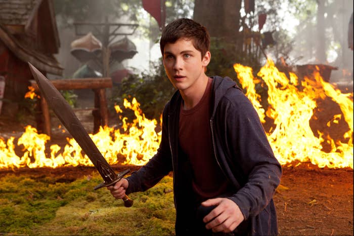 Percy holding a sword in front of fire