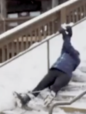 An unsteady skier slips down stairs in the snow