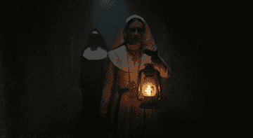 Faceless nun stands over nun&#x27;s shoulder