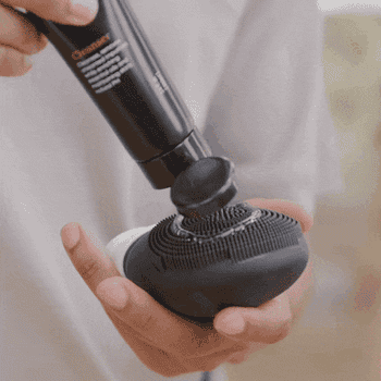 a gif of a model using the facial cleaner and the cleaning brush