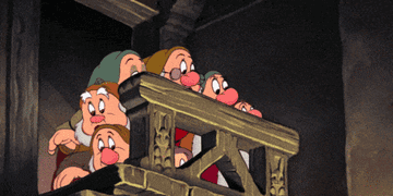 The seven dwarfs looking over the staircase bannister to see what&#x27;s causing a ruckus in a scene from the animated film