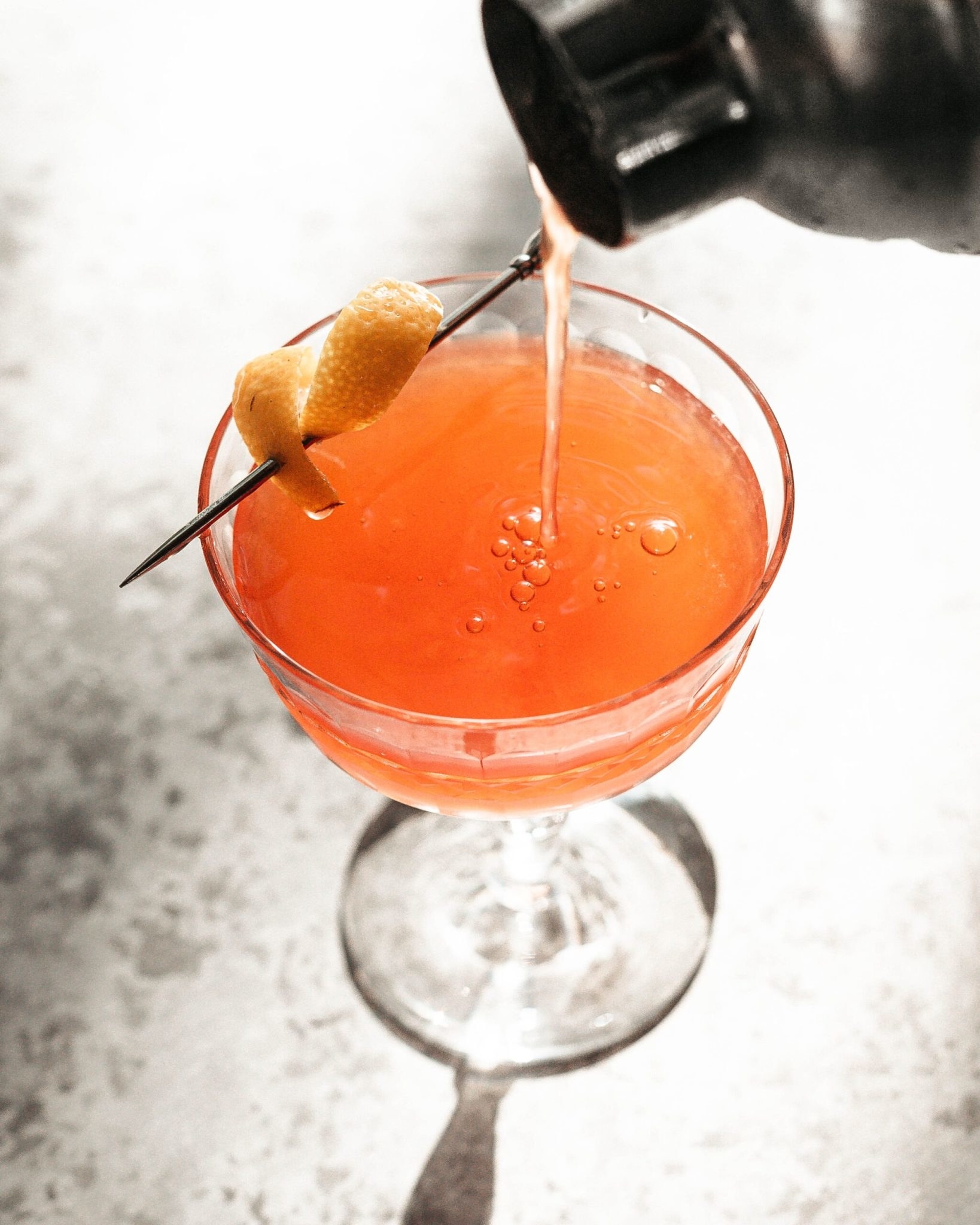 An orange cocktail in a glass