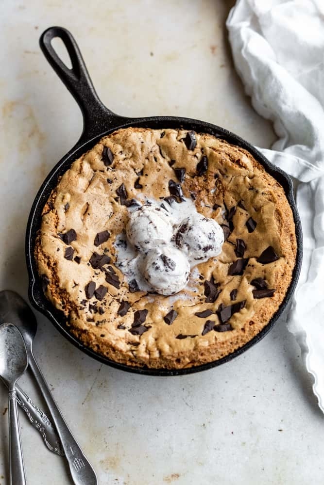 A skillet chocolate chip cookie topped with ice cream
