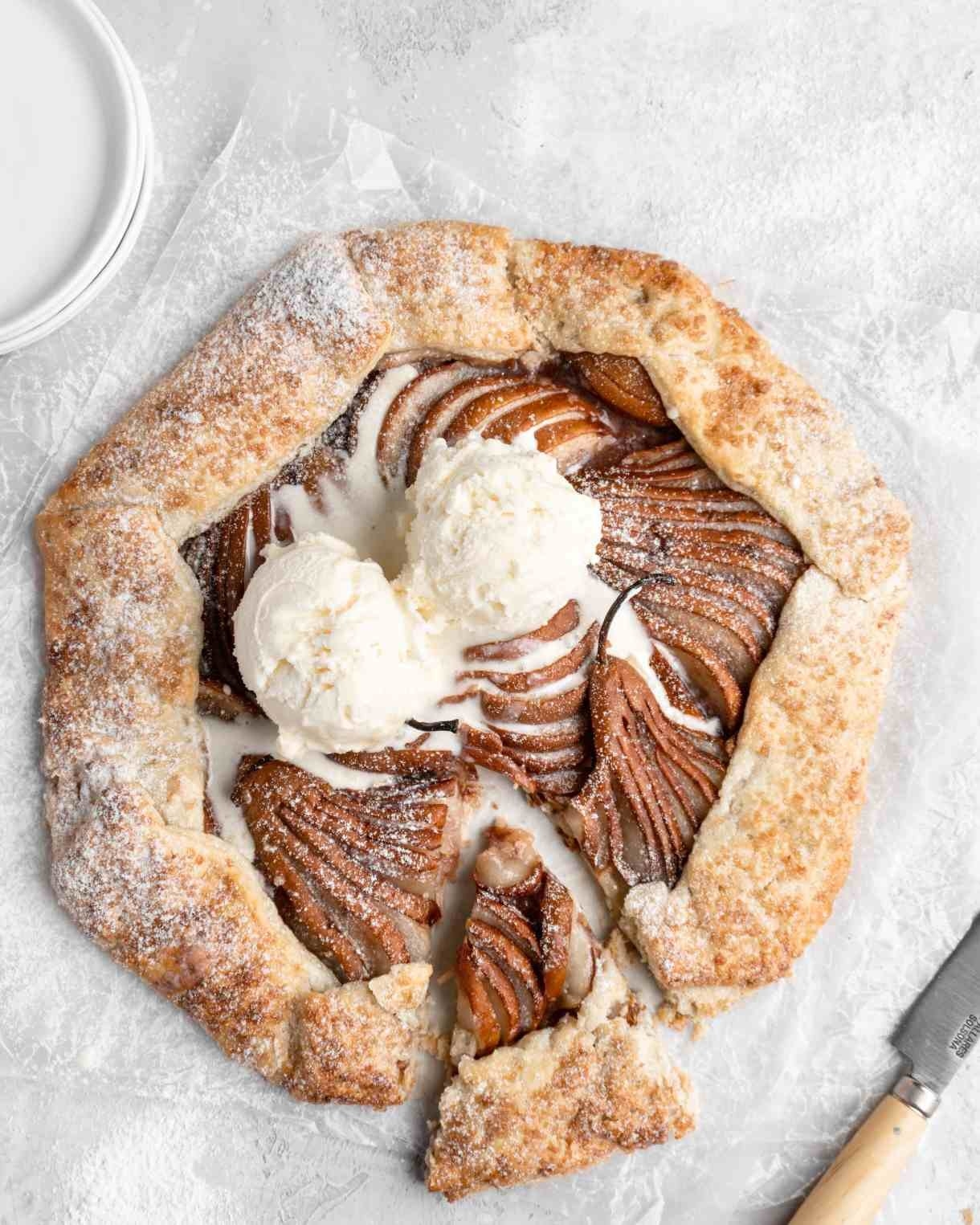 A galette filled with sliced pears and topped with vanilla ice cream