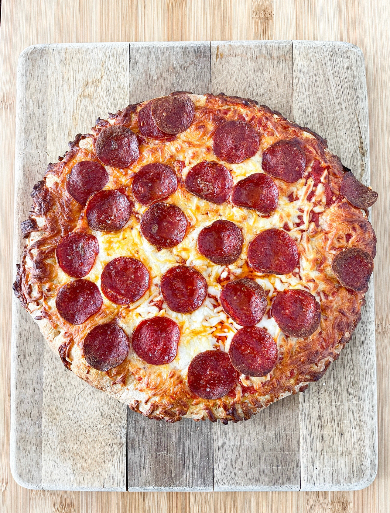 Cooked DiGiorno pizza on a cutting board