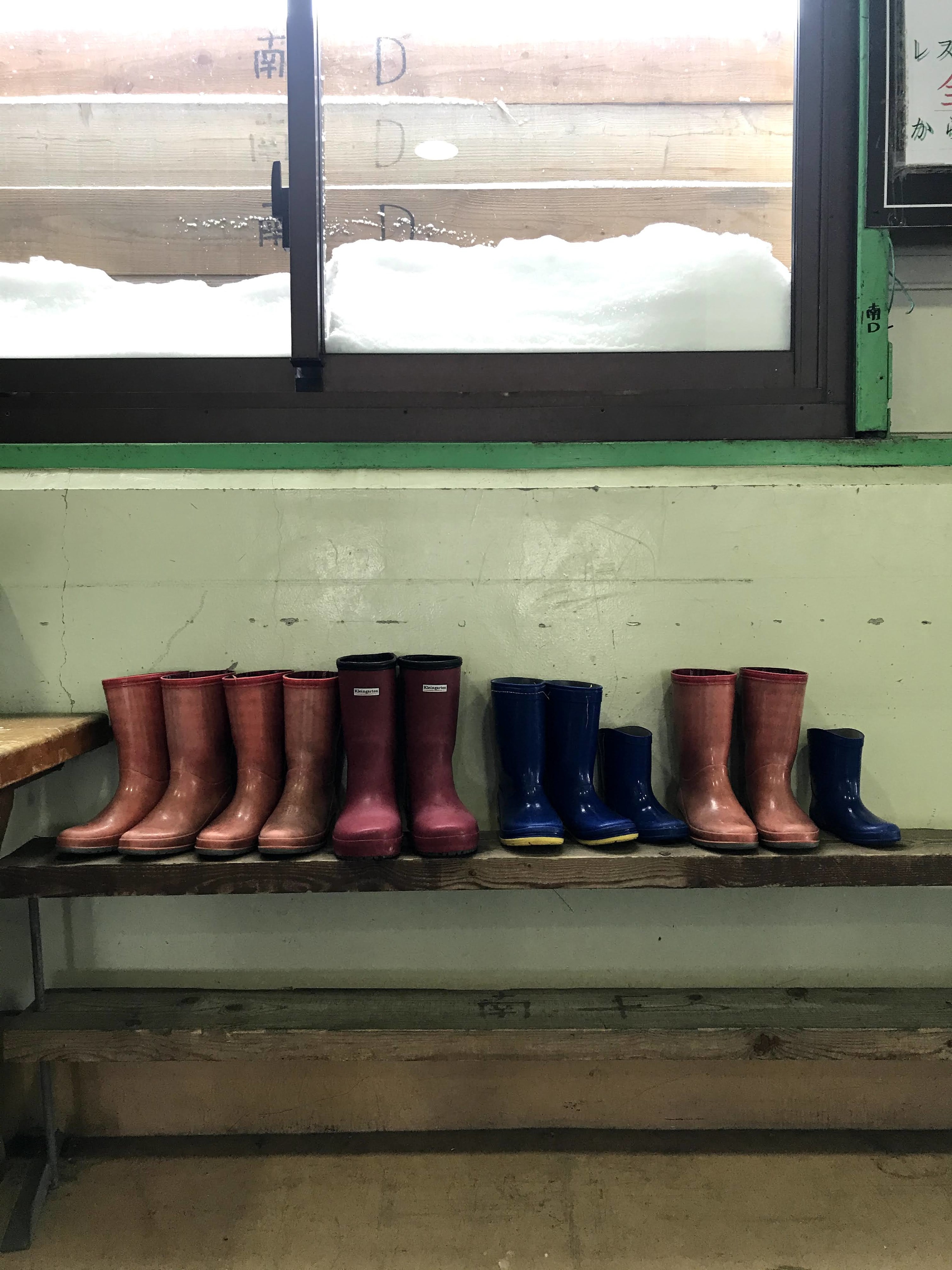 A line of rain boots on a bench