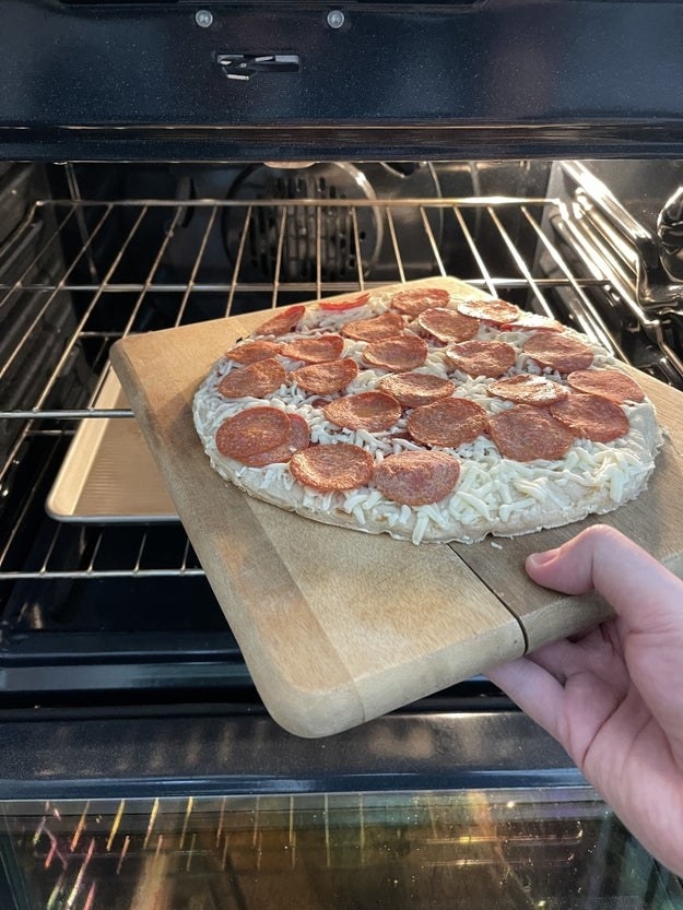 placing pizza in the oven