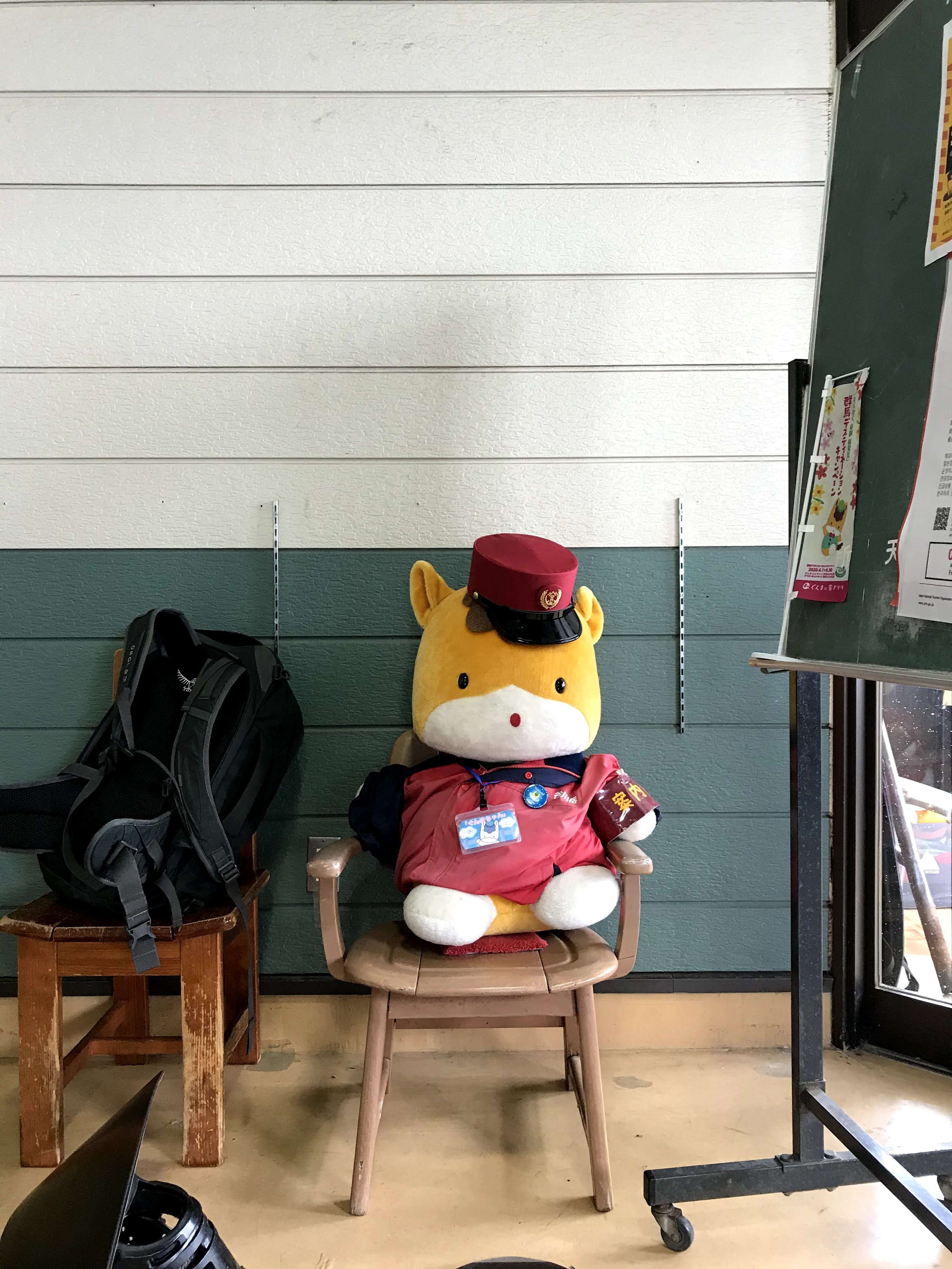 A stuffed animal on a wooden seat